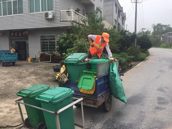 东阳乡一位环卫工正在挨家挨户清运垃圾。新京报记者张胜坡摄