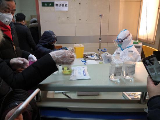1月30日中午，同济医院的医生给排队的患者扎针输液，这条队伍一直排到发热门诊大门口。