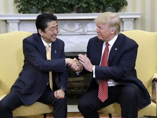 图为2017年2月10日，美国总统特朗普与日本首相安倍晋三在会谈中握手。（美联社）