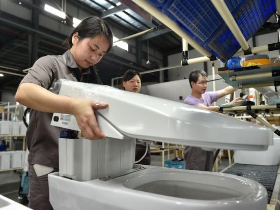在位于福建省南安市的九牧卫浴，工人在组装智能马桶盖（2016年5月10日摄）。