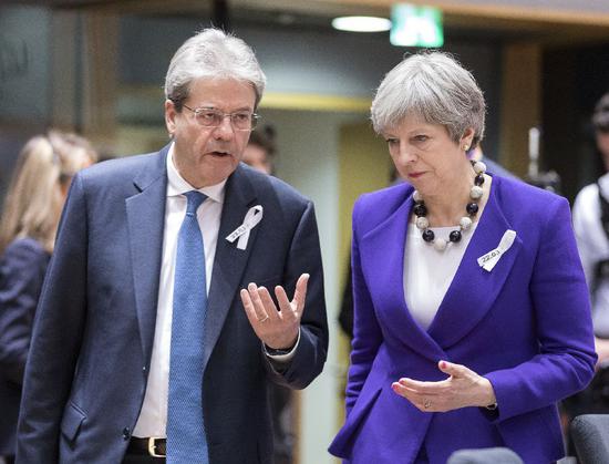 ▲ 欧盟春季峰会上,意大利总理真蒂洛尼(左)和英国首相特雷莎·梅交流。 图/新华社