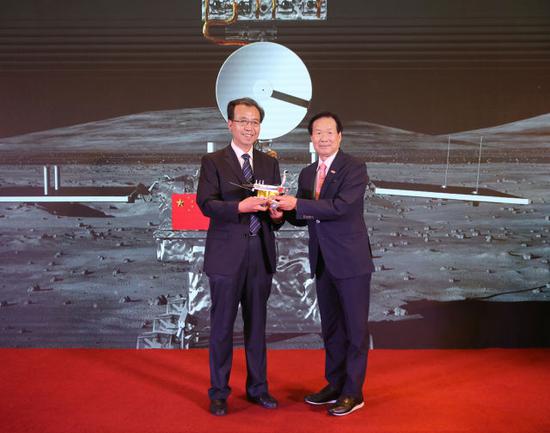 ↑8月15日，探月工程嫦娥四号任务月球车全球征名活动启动仪式在北京举行。图为合作企业美昌集团主席颜培英（右）移交嫦娥四号任务月球车模型。新华社记者 肖磊涛 摄