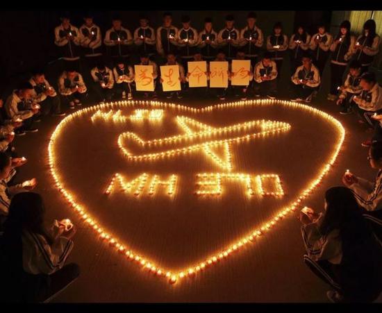 资料图片：中国学生点燃蜡烛为MH370乘客祈福。