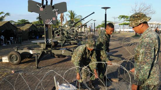 图为菲律宾海军陆战队在峰会会场外安装防空火力。