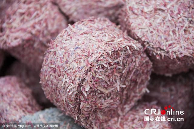 压成“砖块”后的残钞废料依然可以看到人民币原来的纹路。图片来源：视觉中国