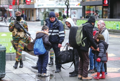 11月22日，比利时军人与警察在首都布鲁塞尔的市区巡逻并检查行人所携带物品。新华社发