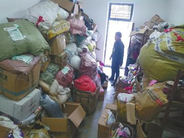 得石镇中心校的储藏室里，捐赠来的衣物堆积成山。
