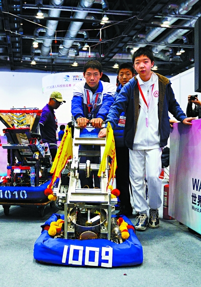 ▲潘逸凡与队友一起推着自己的机器人走进赛场，与另一台刚刚结束比赛的机器人擦身而过。