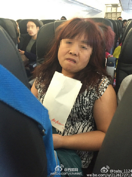 大妈坐飞机脱鞋将脚搭在前排乘客扶手(图)