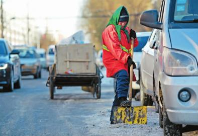 刘福珍老人在路上清雪 新文化记者 史磊 摄 