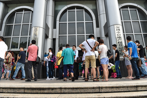 资料图片：市民在深圳市房地产权登记中心外排队等候取号。