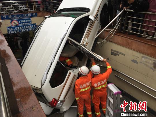 福州一女司机倒车失控掉入地下人行通道，消防官兵紧急施救。 申斌 摄