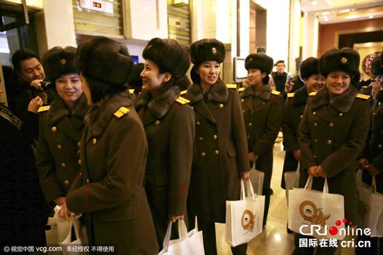 2015年12月11日上午，朝鲜牡丹峰乐团演员参观了北京海洋馆。图为乐团演员手提海洋馆环保袋返回民族饭店。图片来源：视觉中国