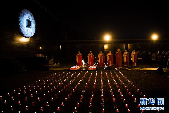  12月13日，僧侣在诵经祈祷。当日，百余名青少年、僧侣和国际友人等在侵华日军南京大屠杀遇难同胞纪念馆的祭场内，手托红烛、低头默哀，为30万南京大屠杀死难者举行守灵暨烛光祭活动。新华社记者 李响 摄