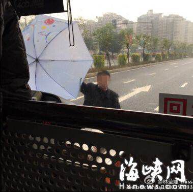 男子要上公交车遭拒，用伞拦在车前。网友供图。