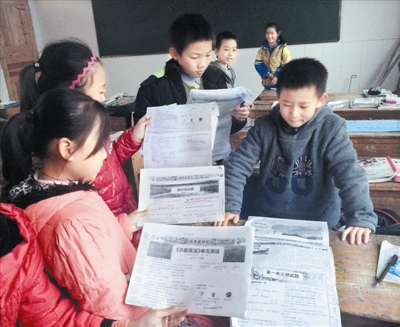 南冈春蕾小学的小学生翻出报纸复印件。