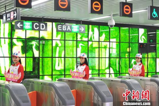图为大学生志愿者站在地铁进站闸前进行礼仪形象服装展示。　刘占昆　摄