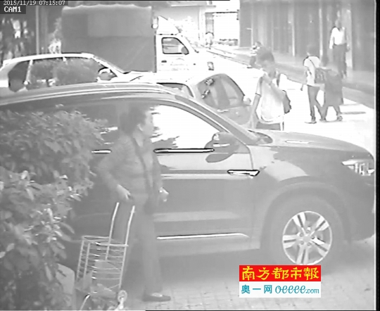 监控视频拍到刮车人右手拖着买菜的篮子车，左手往车上蹭。 视频截图