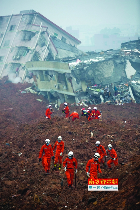 事故发生后，消防官兵分批进入现场搜救幸存者，远处的房子被泥石流冲倒。