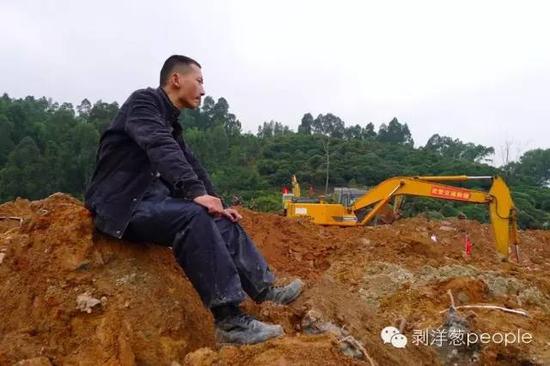 12月22日下午，王永权坐在土堆上，看着挖机来回翻出泥土。