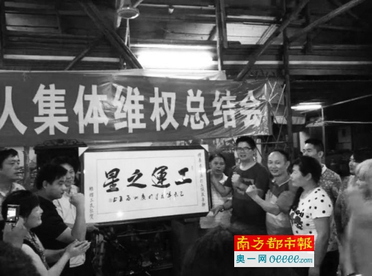 利得鞋厂工人在庆功宴上向曾飞洋赠送“工运之星”牌匾。警方称,该牌匾是曾飞洋自己掏钱请工人制作的。图片来源:南方都市报
