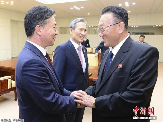 韩国统一部部长洪容杓（左）与朝鲜劳动党统一战线部部长金养建（右）在谈判后握手。