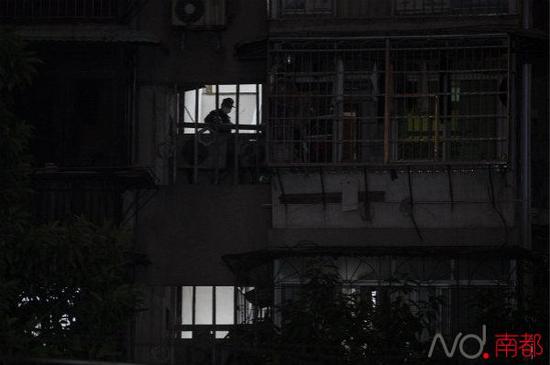 12月30日晚，在事发命案的居民楼里，警方封锁楼道，等待殡仪馆工作人员将尸体运走。 南都记者 黎湛均 摄