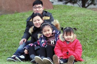 ▲2015年12月10日，山西省临汾市居民王斌、石琦夫妇带着两个女儿在公园里留影。王斌和妻子都生于1985年，是大学同学，又同在医药公司上班。他们的大女儿今年6岁，小女儿今年两岁。　　新华社发