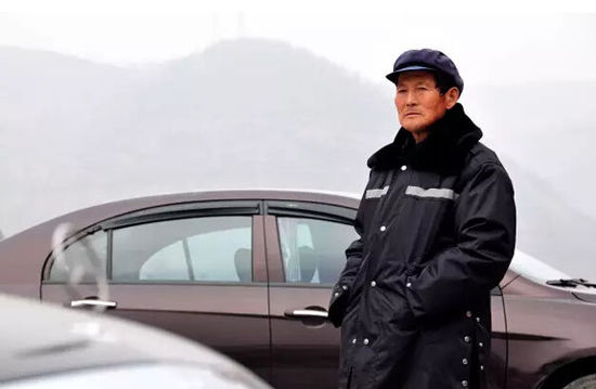 王宪军在停车场执勤。2015年5月1日起，64岁的王宪军成为公司停车场的管理员，过上了和城里上班族一样朝九晚五的生活。新华社记者 梁爱平 摄
