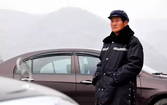 王宪军在停车场执勤。2015年5月1日起，64岁的王宪军成为公司停车场的管理员，过上了和城里上班族一样朝九晚五的生活。 新华社记者 梁爱平 摄