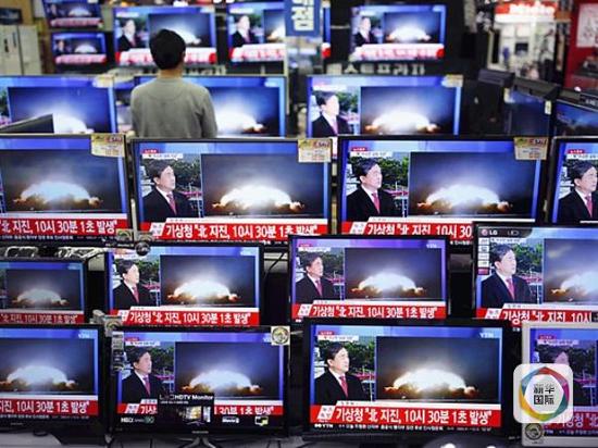 1月6日，在韩国首尔，一名销售员观看报道朝鲜氢弹试验相关新闻的电子屏幕。（新华社路透）