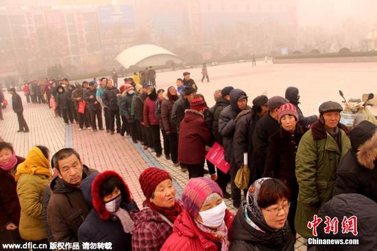 山东聊城雾霾红警 民众排百米长队领挂历(图)|