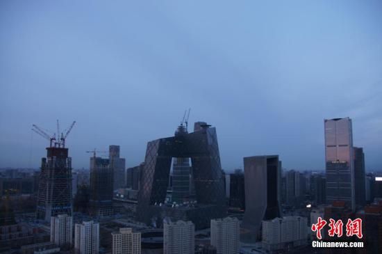 2016年1月4日，继雾霾三天后，北京迎来新年后的首个蓝天，半边天空被朝阳映得通红，初升太阳如同蛋黄。图片来源：视觉中国