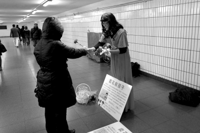 孩子父亲扮女装地下通道卖花。 京华时报记者 陶冉 摄