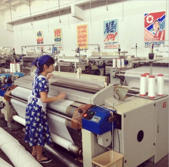 2014年9月14日，平壤纺织厂一名年轻女工正在工作。