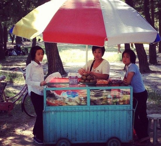 科克雷尔在元山(Wonsan)海滩附近抓拍到这些正出售各种零食小吃的女子，元山是朝鲜江原道海港城市。