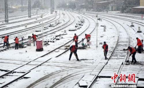 2016年1月21日，南昌铁路局南昌车辆段的工人们正在九江客技站清扫线路和道岔上的积雪。　胡国林 摄