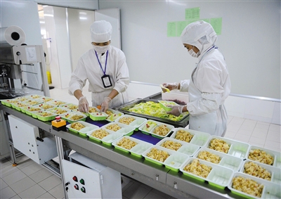 2015年8月4日，在江西南昌县小兰经济开发区的高铁盒饭生产工厂，工人们正在包装盒饭。图/CFP