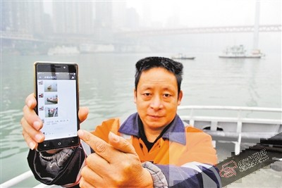 雷春林告诉记者，为打捞水面垃圾，他们在手机上建了微信江面垃圾打捞呼叫群。 本报记者 杨新宇 摄