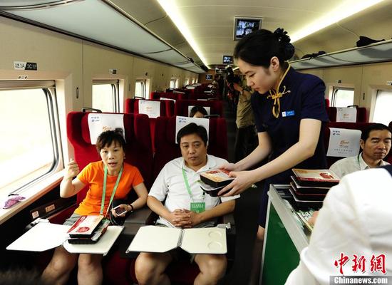 ▲ 2011年，前往上海的列车上，服务员为一等座席的乘客送餐