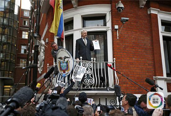 2月5日，在英国首都伦敦，“维基揭秘”网站创始人朱利安·阿桑奇在厄瓜多尔使馆阳台上手持联合国工作组的调查报告对媒体讲话。（图片来源：新华社/路透）