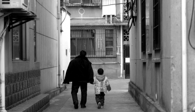 靳军华年迈的父亲步履蹒跚，牵着3岁的孙子回家。