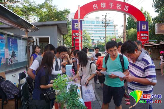 北京大学环境科学与工程学院2014级硕士班党支部联合白堆子社区党委在社区内开展绿色环保承诺书、绿植入户、废物利用等"红色1+1"共建活动。王剑供图
