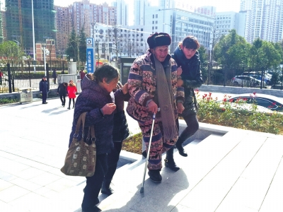      昨天，陈家杨（中）在家人搀扶下走向法院。京华时报记者 张思佳 摄