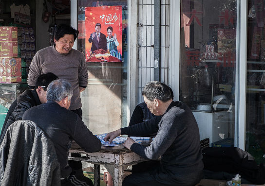 人们聚集在倪家的棋牌室里，倪林荣在看村民们搓麻将。