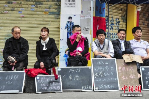 资料图:2019-05-22,广州海珠区康乐村,小制衣厂的老板和管理人员拿着简易的招工牌在路边招工。中新社发 陈骥旻 摄