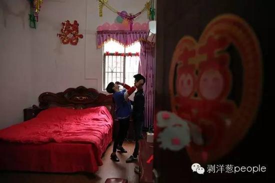 2016年2月24日，广西马山县，张家乐和吴明敏的婚房里，吴明敏被逗得哈哈大笑。16岁的张家乐和吴明敏今年正月“结婚”摆酒。（人名皆为化名）新京报记者薛珺 摄