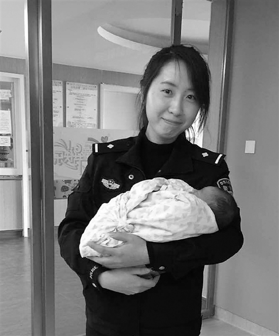 宝宝在女警怀中睡得香甜。