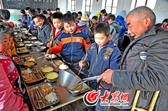 每天中午，冯佃生都要在东卸甲小学的食堂里帮学生们打饭。