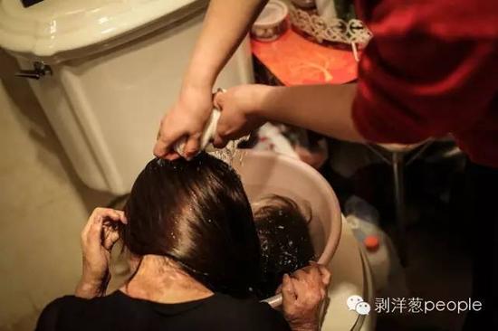 周岩在母亲的帮助下洗头。新京报记者彭子洋 摄